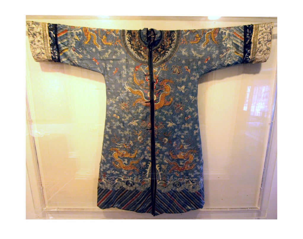 A stunning blue silk dragon robe dated to late 18th possibly earlier, the mid-Ching dynasty of China. The robe is embroidered with gold thread with cloud formations, longevity motifs and eight five-claw dragons in the front, back and shoulder. It