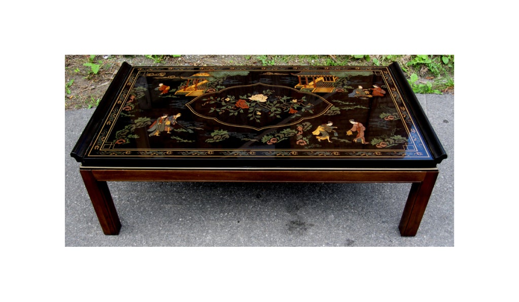 A Lacquered coffee tables by Drexel Heritage in an oriental Chinoiserie taste. It features squared mahogany legs supporting a black lacquered top with raised edges. The delicate design on the top surface was masterly done with oriental figures in a