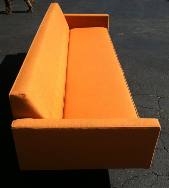 Classic long sofa designed by George Nelson for Herman Miller. Original burnt orange wool fabric with tufts on the back. Linear structure, solidly built with steel legs.