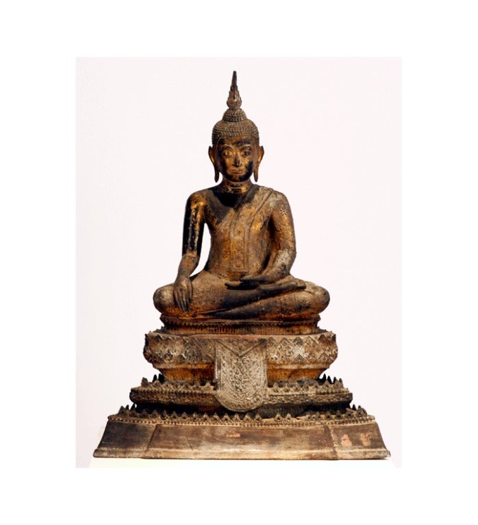 This bronze Buddha statue was cast in a traditional style found in the late period of Ayutthaya Kingdom in Thailand (1350-1767), dated from Bangkok Period circa 19th Century. The Buddha is majestically seated on a three-tier throne in a 