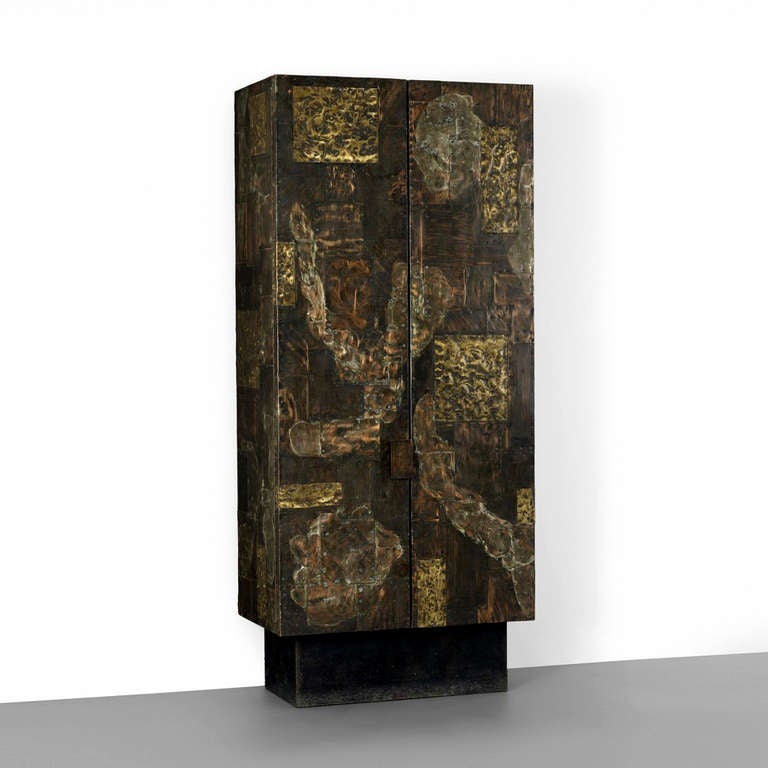 A tall vertical cabinet or wardrobe with double doors designed by Paul Evans for Directional circa 1970s. The cabinet on pedestal is part of the patchwork series in which sheets of metals such as copper, bronze and pewter were patinated and hammered