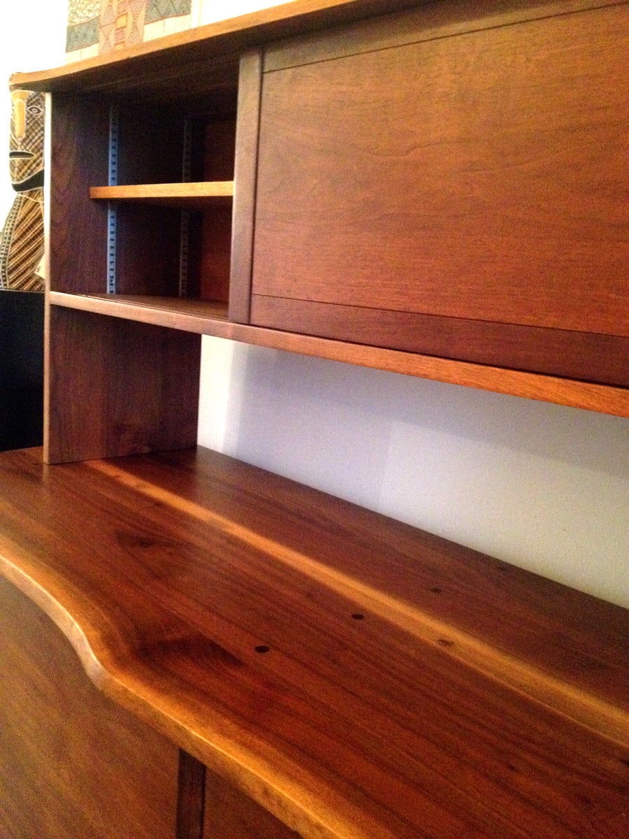 A two-piece custom sideboard pr credenza handcrafted by George Nakashima, circa 1969 in his new hope studio. It is constructed with American black walnut with solid oak interiors. The lower sideboard features a frontal free edge displaying the