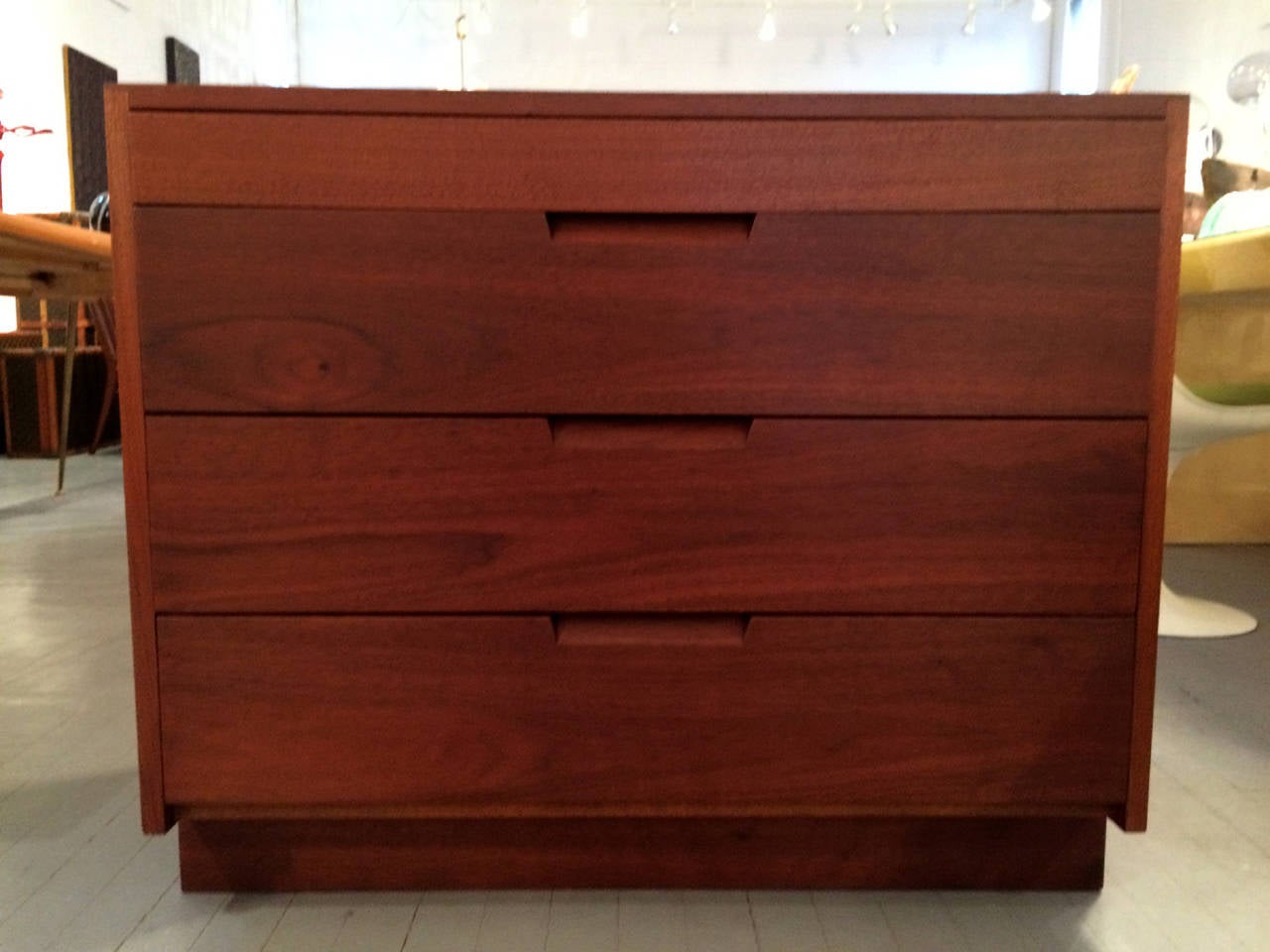 An early pair of chest of drawers or commode hand crafted by George Nakashima in his New Hope studio in 1955. They were made from American walnut and each features four drawers with carved recessed pulls and plank feet. They are elegant classic