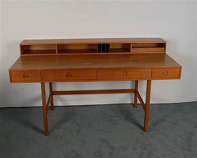 Danish Modern Teak desk by Jens Quistgaard for Lovig and distributed by Dansk. It has a very cool flip top part on top with two tray drawers and storage slots. The desk itself features  four drawers in front and storage at back. Lovely design that
