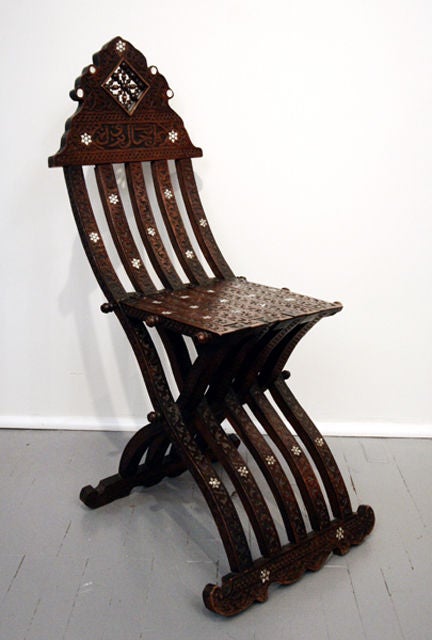Beautifully carved folding chair from Mideast. Inlaid with mother pearl star pattern. Solid teak and nice patina.<br />
<br />
This item is located at Tishu Hudson.