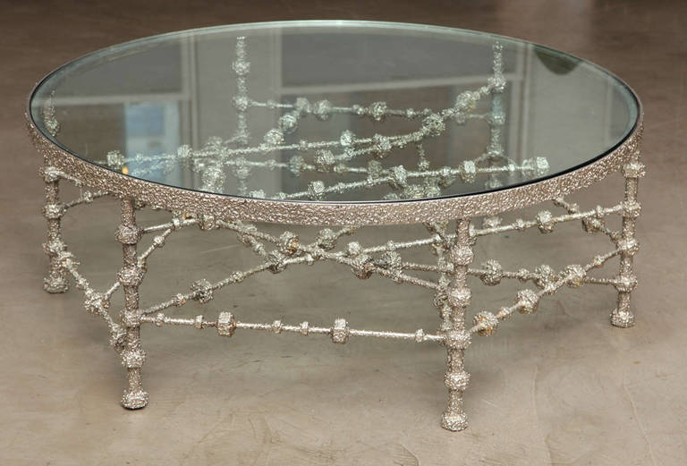 One-of-a-kind low table with chrome patinated steel bolts base and glass top.