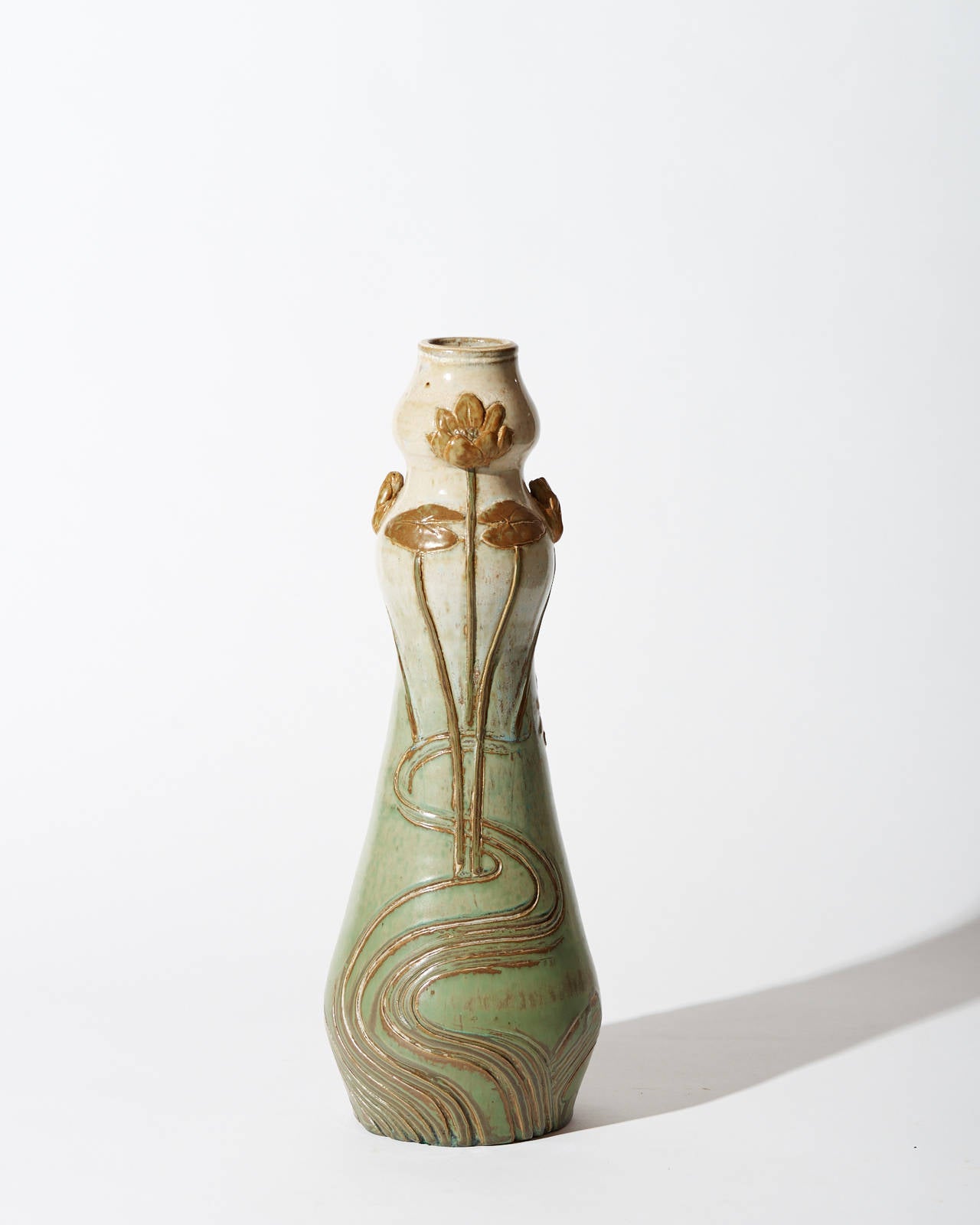 Designed by Emile Belet for Paul Milet. The form of this elegant vase is Based Upon the traditional double-gourd, which is used here as the neck of a bottle-shaped vessel. Whiplash stems and stylized flowers and leaves are applied, further detailed