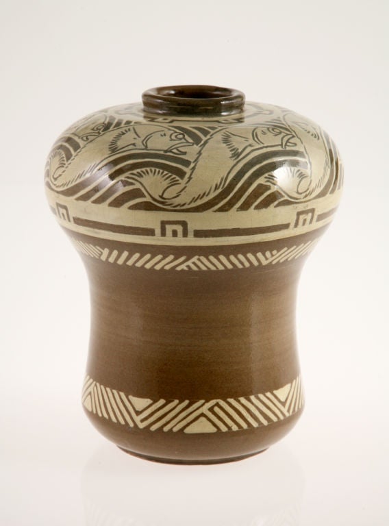 An unusual stoneware vase with a painted design of fish swimming through stylized waves on the shoulder and bands of geometric and linear decor on the body beneath. While Lenoble often combined floral motifs and non-figural patterning, his use of
