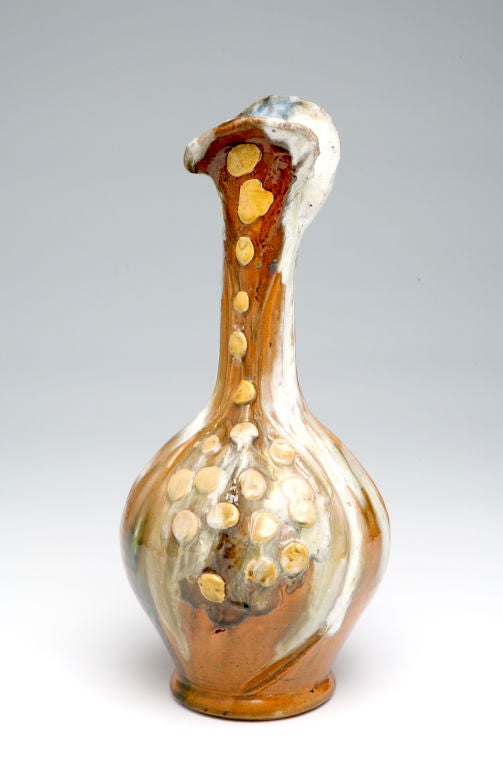 This long-necked vessel with a globular body is as infused with life force as the flowering bulbs to which it seems to allude. With no area devoid of the physical characteristics and chemical action of clay, glaze, and fire, this vase suggests the