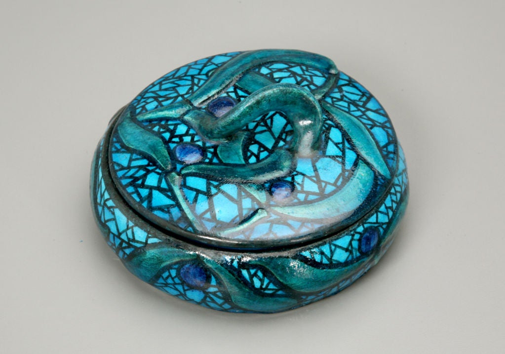 The twisted finial, part of an overall mistletoe motif used in the bowl shown above, evokes the swirling rhythms of Art Nouveau, which was out of favor by the time the bowl was made in c1918. By the mid-1920s, Jean-Jacques Lachenal abandoned this