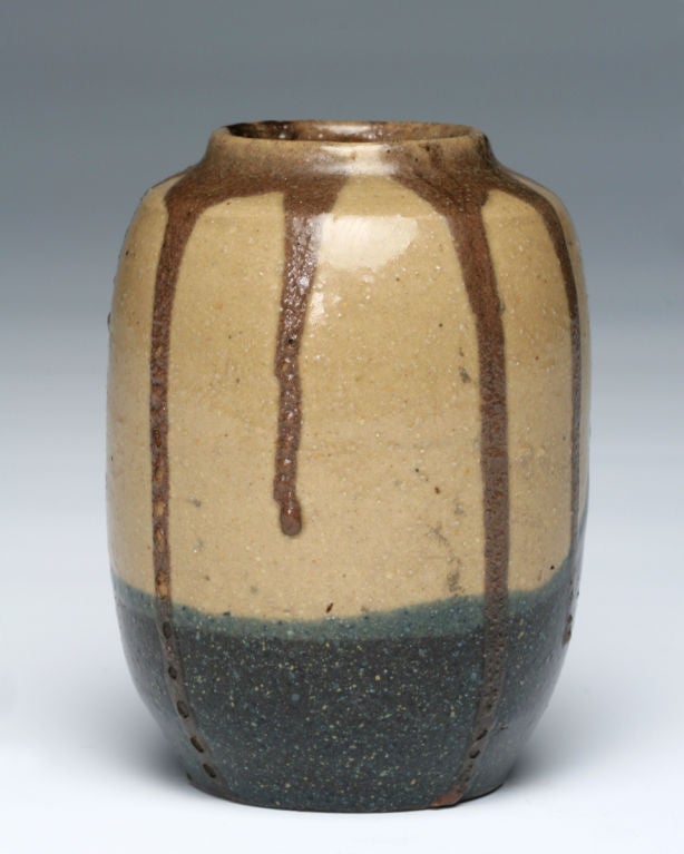 The brown, tan, and blue glazes on this highly desirable cabinet vase were achieved by firing the stoneware piece at a high temperature. The result bears only a serendipitous resemblance to a blue wave crashing on a rocky shore. Lion worked in the