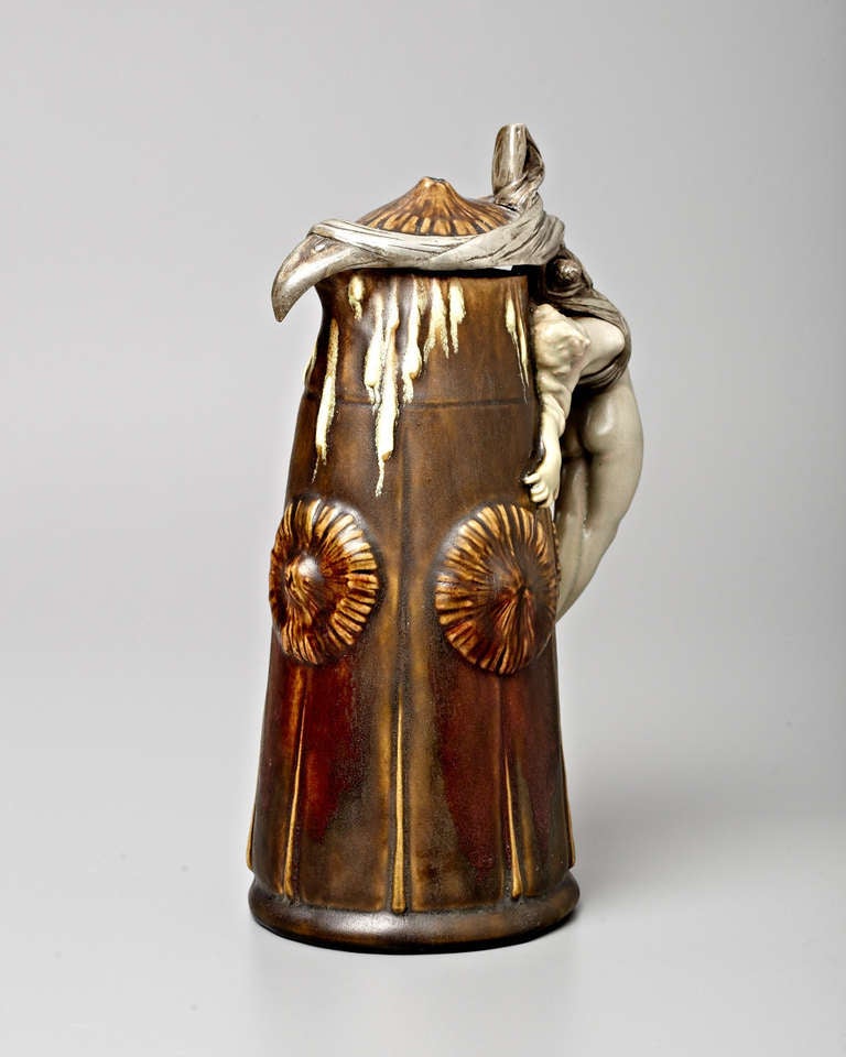 This extraordinary beer tankard seems to be designed for the erotic titillation of male consumers, who might reasonably be attracted by the seemingly unconscious maiden whose dangling naked body, back arched, forms a handle connecting the hinged