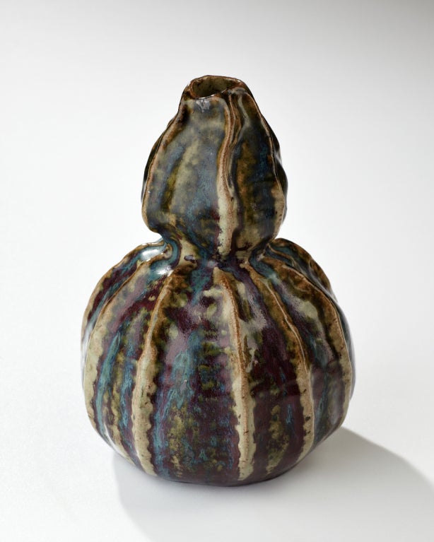 With puckered lips, cinched waist, and ruffled gores, this double gourd vase has a decidedly feminine character. The irregularities of the surface encouraged the glazes to stream and shed in predetermined directions, while the high temperature in