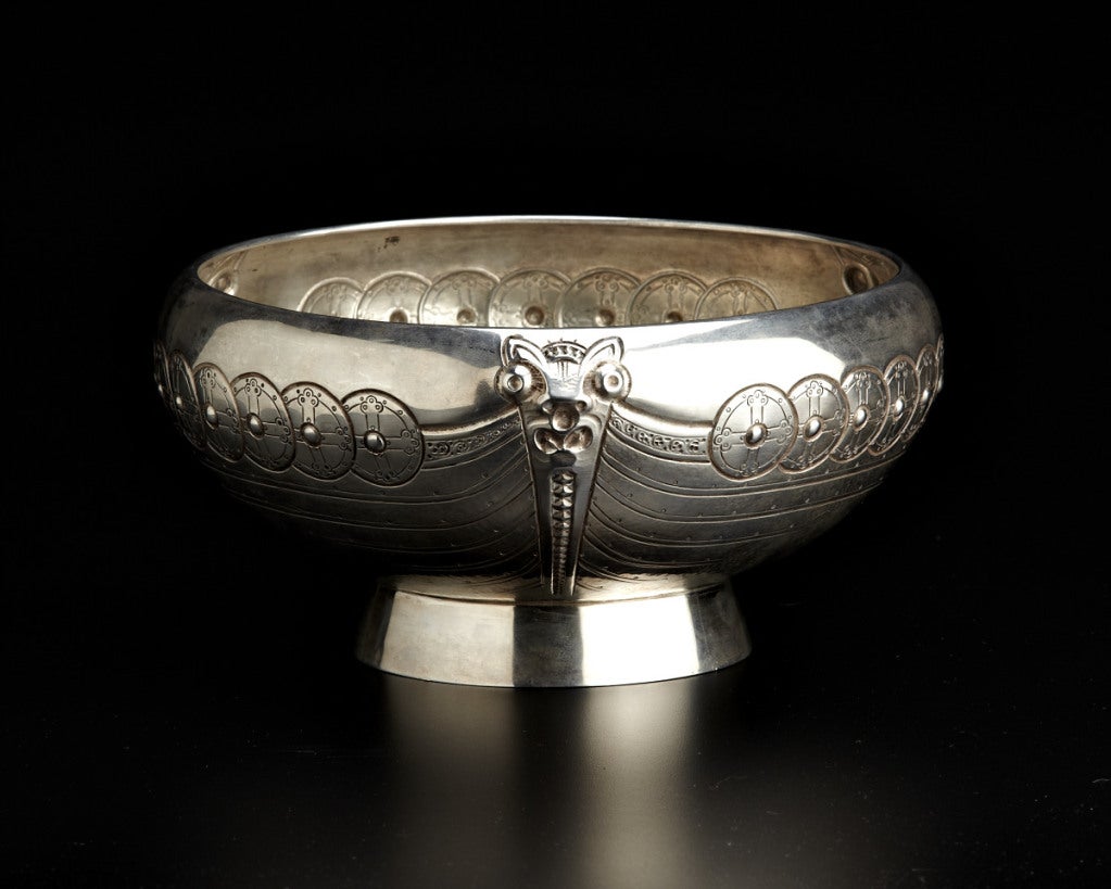 This handsome bowl features three identical profiles of a Viking ship conjoined by three dragon-shaped prows. The inside features a hand repoussé pattern designed to represent the ribs of a ship's hull.  J. Tostrup was a paragon of the Norwegian