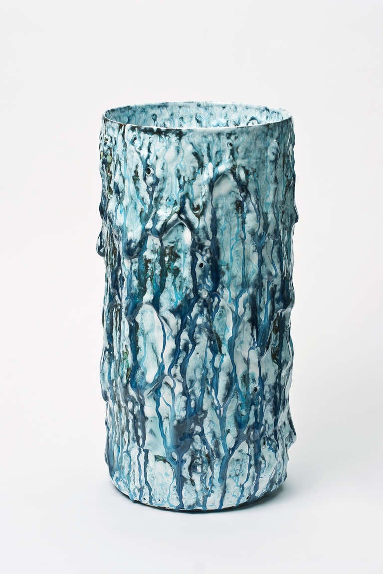 This cylindrical vase recalls the sea it has rough coral like texture and blue drips running down the sides. 
Espersen brings fresh and exhilarating energy to the pedigreed tradition of Danish ceramics. His works can best be described as the bold,