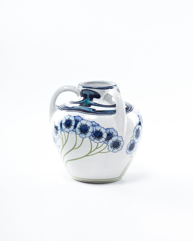 A lovely example of the Liberty style in Italy, this tri-handled vase is finely hand-painted in shades of blue and pale green, set against a crisp white ground. Beautiful blue poppy anemones with long slender stems, which cleverly flow upward from a