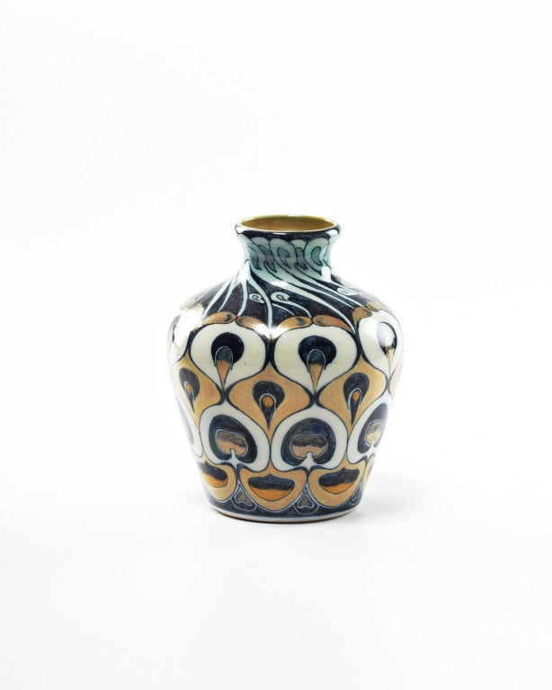 This exquisite earthenware vase by Galileo Chini, boasts a magnificent hand-painted design of stylized peacock feather eyes, in shades of blue, gold and white. The graceful curvilinear patterns and iridescence of it's decadently beautiful tail