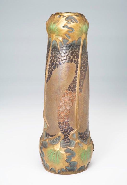 Paul Dachsel for Ernst Wahliss. This monumental, almost-cylindrical vase swells into two near-globes at the head and foot. The low-relief gold and green palm leaves at the top are likewise mirrored at the bottom, with connecting stems ornamenting