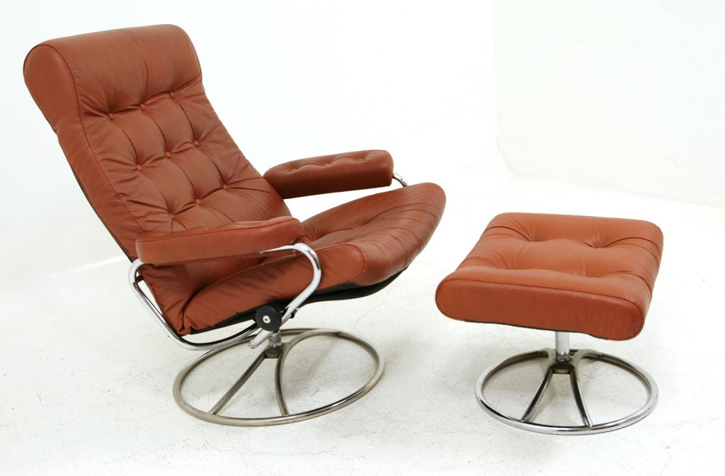 Fantastic example of the original model of the Ekorners Stressless arm chair with the matching foot stool. Chair is totally original with the reddish, burnt umber leather in remarkable condition.