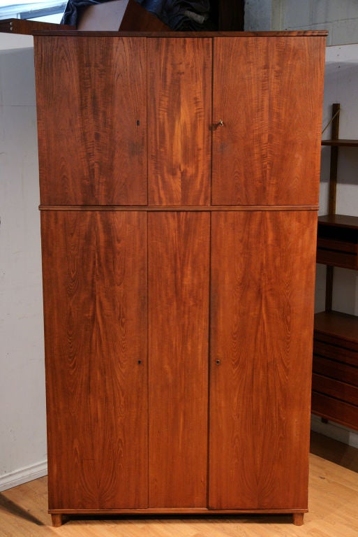 Teak wardrobe cupboard from Denmark, 1960's. Completely dismantles into flat pieces. Hanging area below with shelving in upper portion. Minor chipping to the edges on right hand side.