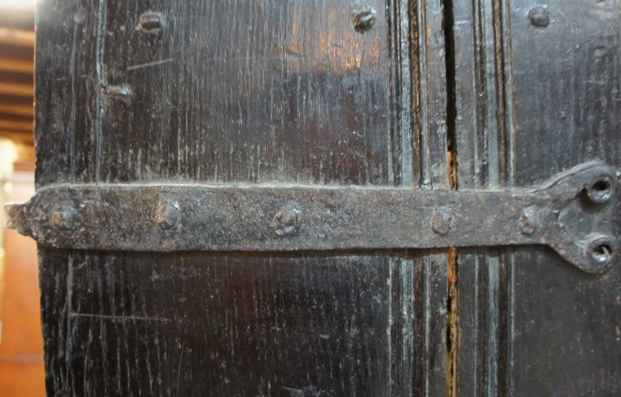 An original, antique English door crafted of solid elm with large forged iron hinges. This early, hand hewn plank door came from a historic cottage in the Cotswolds in Southern England. It is in original, unrestored condition and is a genuine and