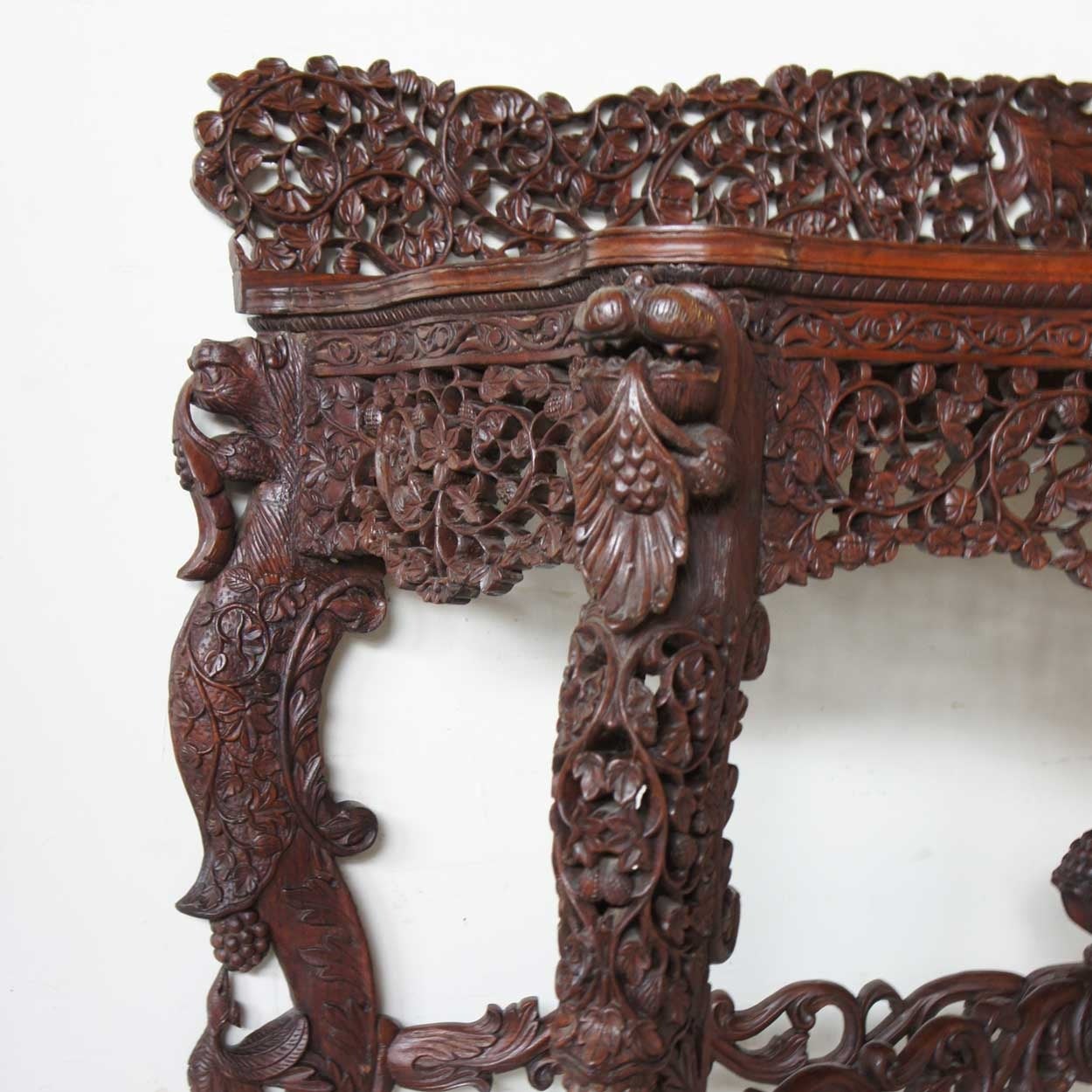 This very rich and elaborate pair displays the finest craftsmanship from the artisans in the colonies. Each piece is intricately carved in floral motifs, throughout the back boards, the unusually deep aprons, X-stretchers with central pediments, and