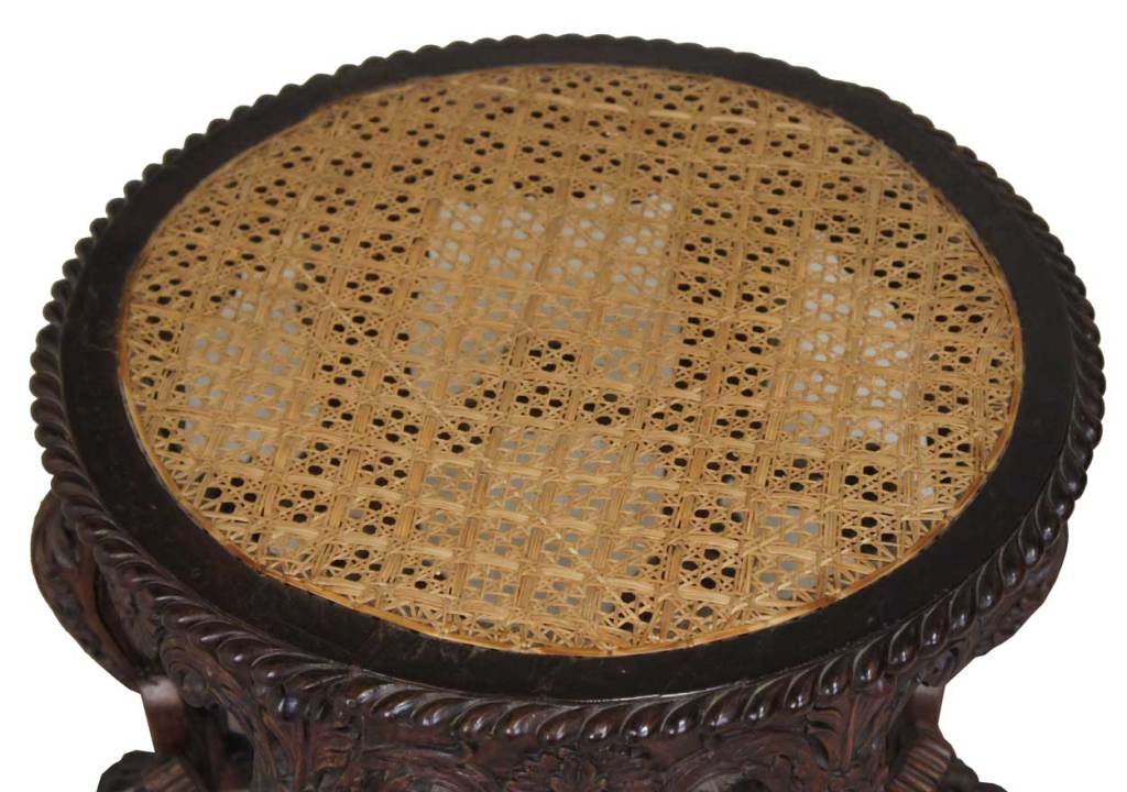 Expertly hand crafted, in the robust Portuguese style with a caned top, this little stool could double as a small occasional table. It features six bold, foliate, beautifully carved cabriole legs that terminate on paw feet. The legs support an