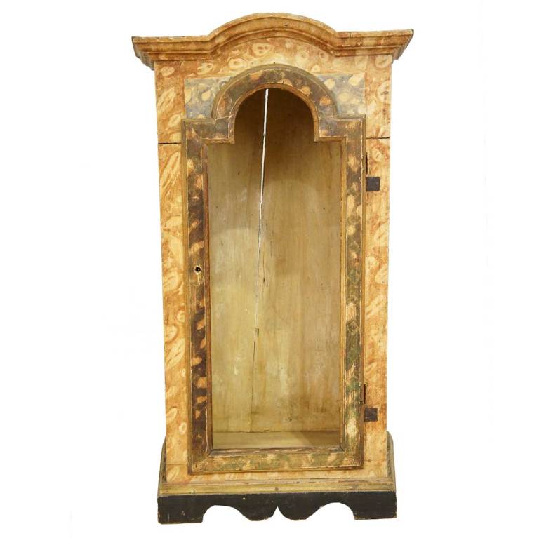 This table-top display cabinet was hand fashioned with an arched, bonnet top and well defined moulding around the arched top door opening (note: no glass). It displays the original painted finish with faux-marbling and canted corner side panels and