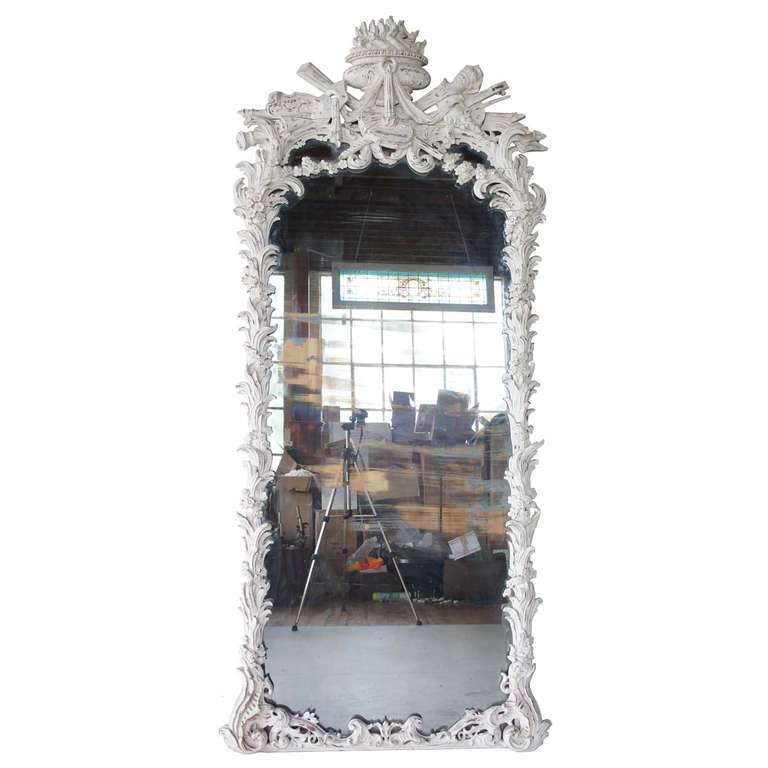 Hand carved of oak, displaying musical and theatrical trophies and a carved urn, all surmounting the unusually large, rectangular mirror plate. The continuation of the frame is carved with leafage, bulrushes and flowerheads, making this a very