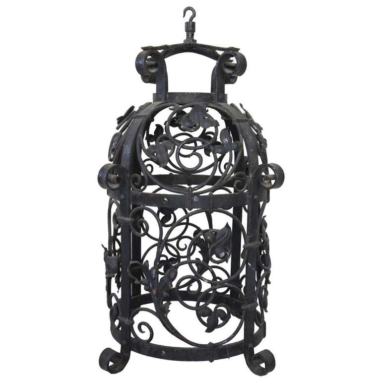 This antique, late 19th century light fixture is crafted of wrought iron with a round frame decorated with elaborate scrolling vines. The workmanship is very fine quality. Originally designed for exterior use it could also be used indoors. Note: the