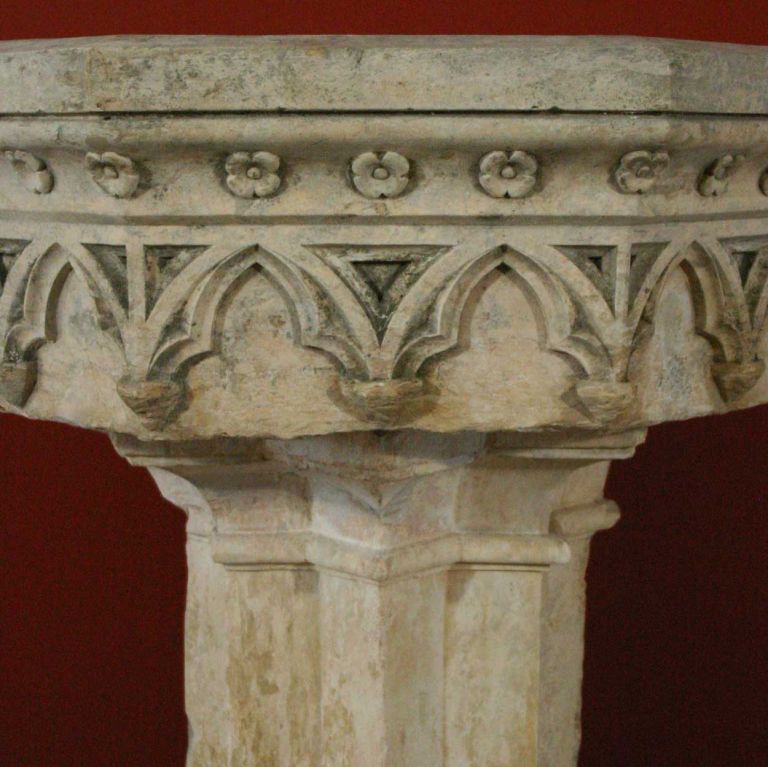 Hand carved in Gothic Revival style, this exceptional , demilune basin features beautifully carved Gothic arches on the five-sided apron and an unusual star-form pedestal. From the region of Burgundy, it is crafted of local, hard stone. It is