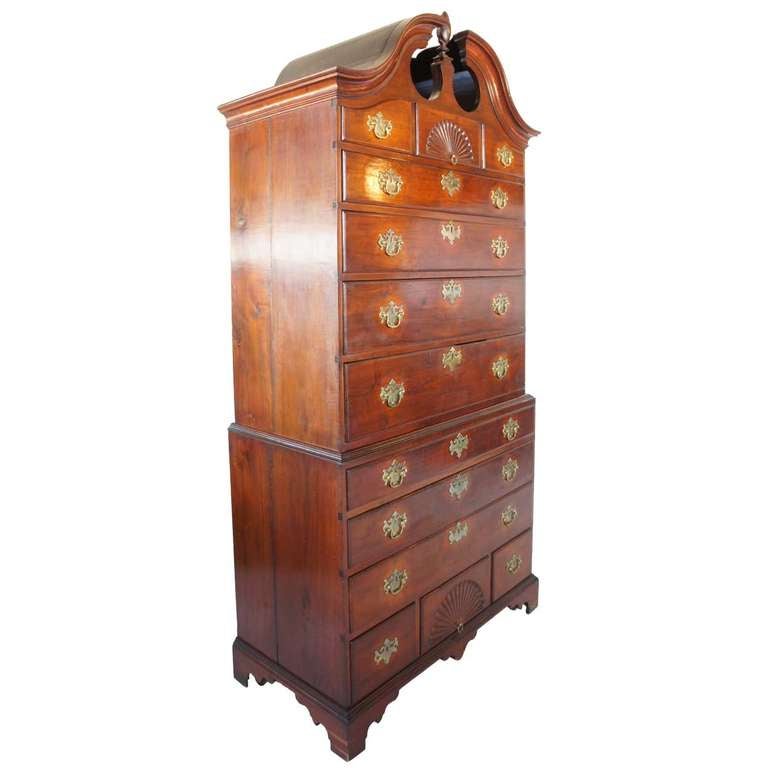 With paper label (on reverse): Winthrop Tappan/ Bath/ Maine. This beautiful period chest features a broken arch top with a tall flame finial over a fan carving flanked by two short drawers, over four graduated long drawers. The bottom section