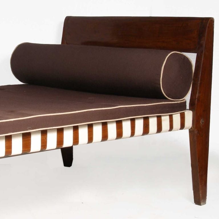 Pierre Jeanneret (Swiss, 1896-1967)<br />
This mid century modern day bed is crafted of solid teak, with a low open framed headrest, the base with webbed straps supporting a mattress and bolster cushion.<br />
Bed H: 17
