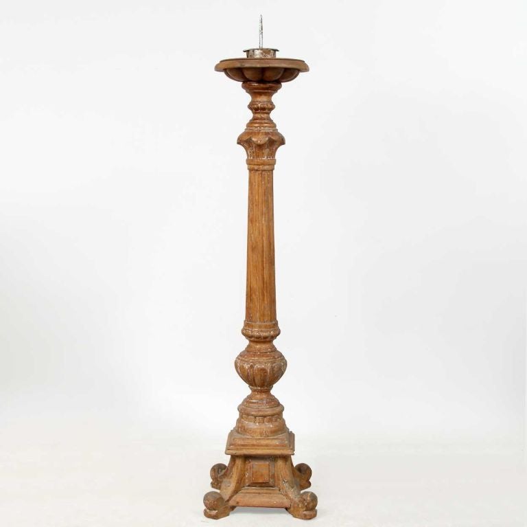 This impressive pricket stick was beautifully fashioned with a broad candle drip pan, with a deeply gadrooned bottom and a reeded column over a gadrooned urn, sitting atop a square, moulded base with scrolled feet. It is a warm, terra cotta color