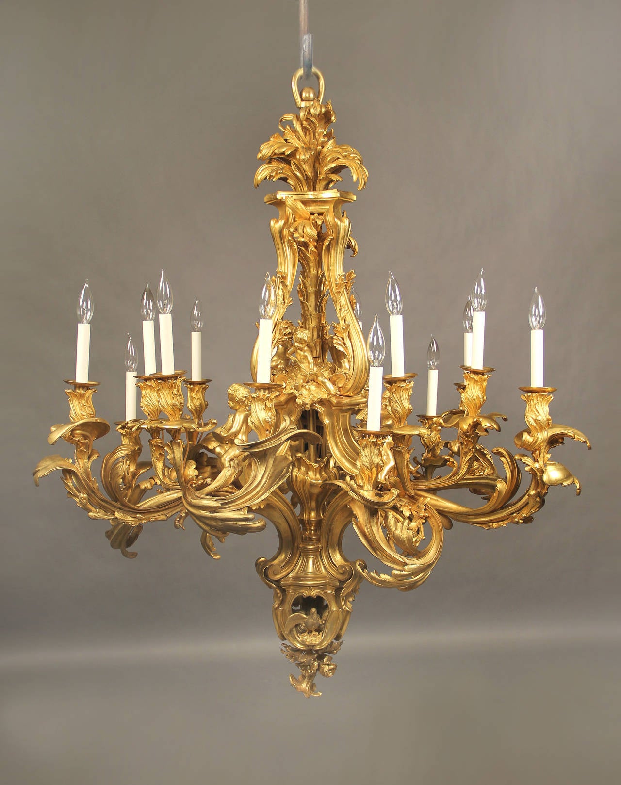 A magnificent and palatial late 19th-early 20th century gilt bronze fifteen-light chandelier.

After the famous 18th century model by Jacques Caffiéri.

This wonderful chandelier is centered by a baluster shaped open central stem, surmounted by