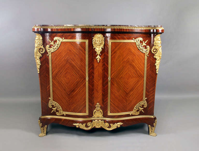 A wonderful late 19th century gilt bronze mounted Louis XVI style palace size cabinet.

Marble top above two doors. centered by a lovely female mask, the sides of bearded men. Quartered veneered with a beautiful diamond design. Standing on lion