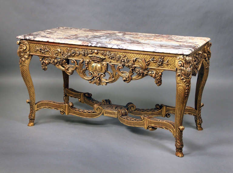 A Very Finely Carved Late 19th Century Regence Style Giltwood Console

The shaped rectangular brèche marble top above a latticework frieze and pierced foliate apron centered by a coat-of-arms, on acanthus-carved cabriole legs joined by a wavy