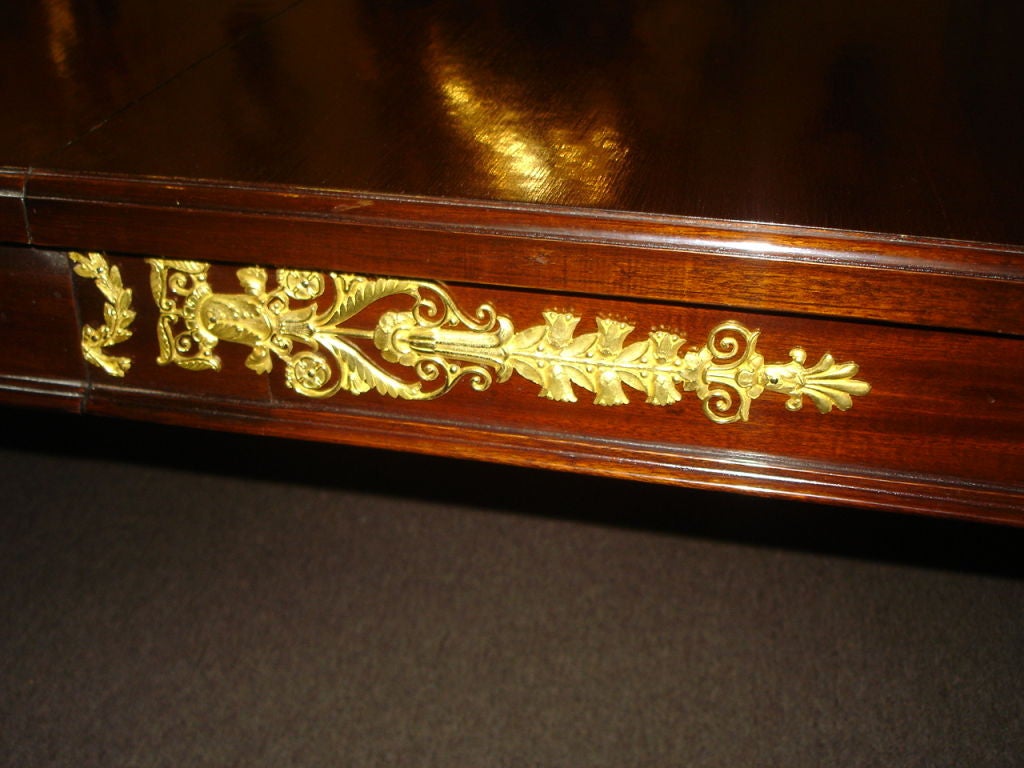 A large and important late 19th century gilt bronze-mounted Empire style dining room table. There are two leaves that extend the table.

The table is 140