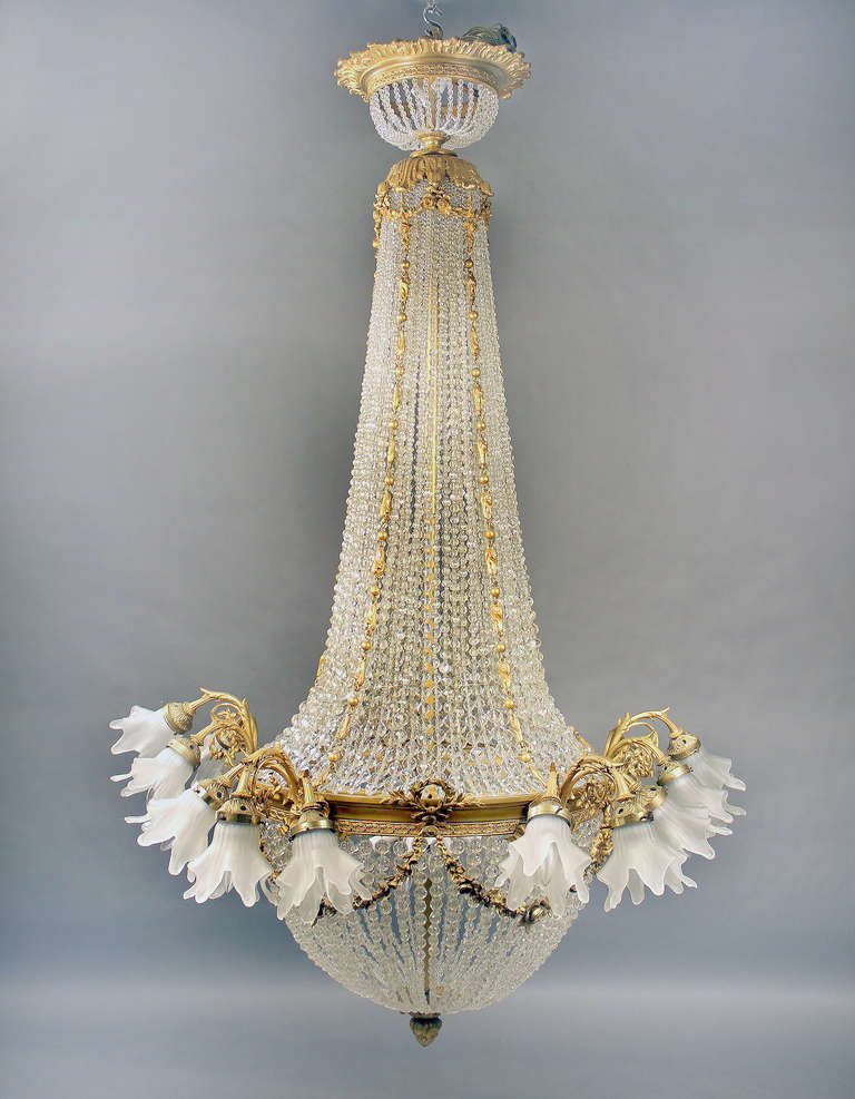 A large and impressive late 19th century gilt bronze and beaded baccarat crystal twenty-nine-light basket chandelier.

Finely casted bronze arms supporting fifteen perimeter lights with fourteen tiered interior lights.

If you are looking for a