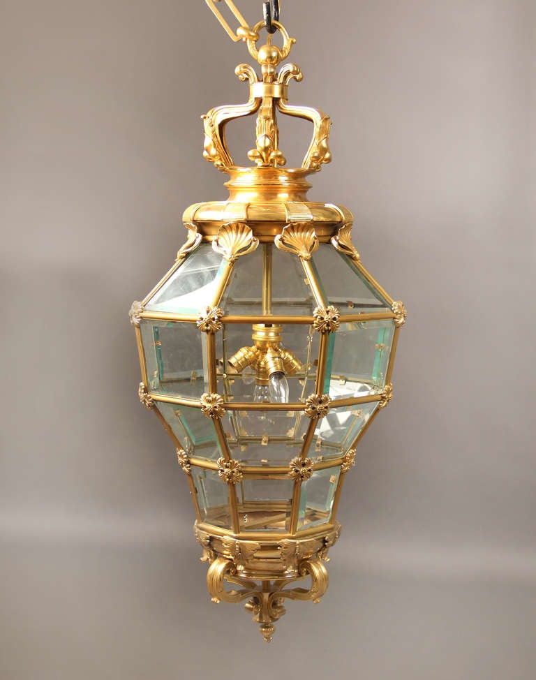 A Late 19th/Early 20th Century Gilt Bronze and Glass 'Versailles' Hall Lantern

After the Versailles model, of octagonal and cage form, with a corona finial above scallop shells, five interior lights.


 