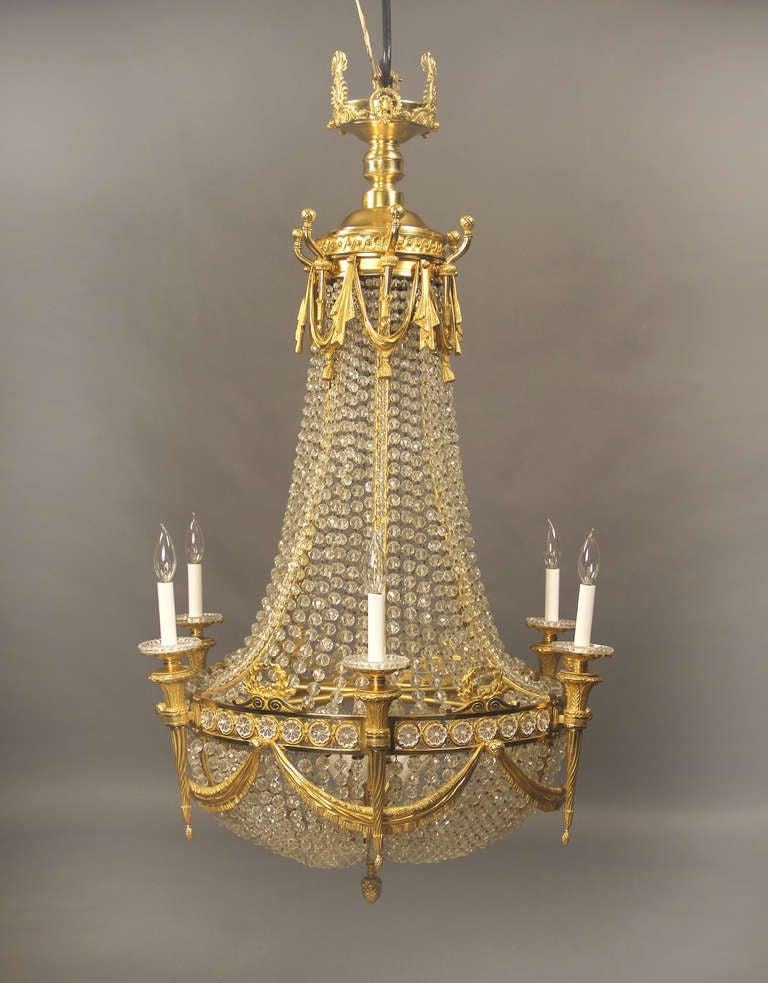 A fine late 19th century gilt bronze and beaded basket eighteen light Baccarat crystal chandelier.

In the Russian Empire style.

Six perimeter lights shaped as torches and twelve interior tiered lights, Classic Empire bronze designs.


If you are