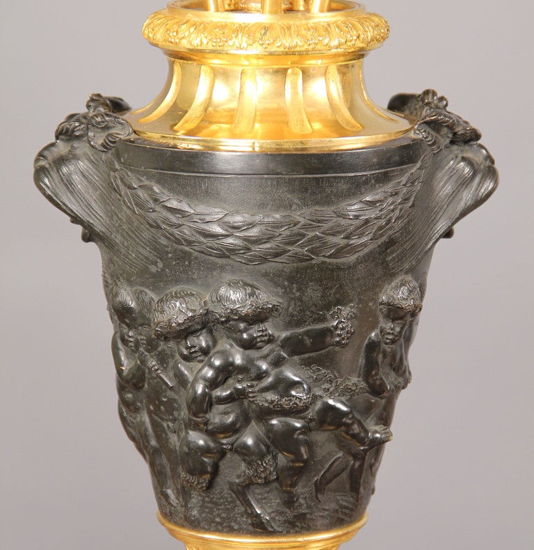  Paire de candélabres à six lumières en bronze doré et patiné de la fin du 19ème siècle 

D'après Claude-Michel Clodion

Chaque vase, de forme effilée, est orné de deux masques grotesques suspendus à des guirlandes de laurier, au-dessus d'une frise