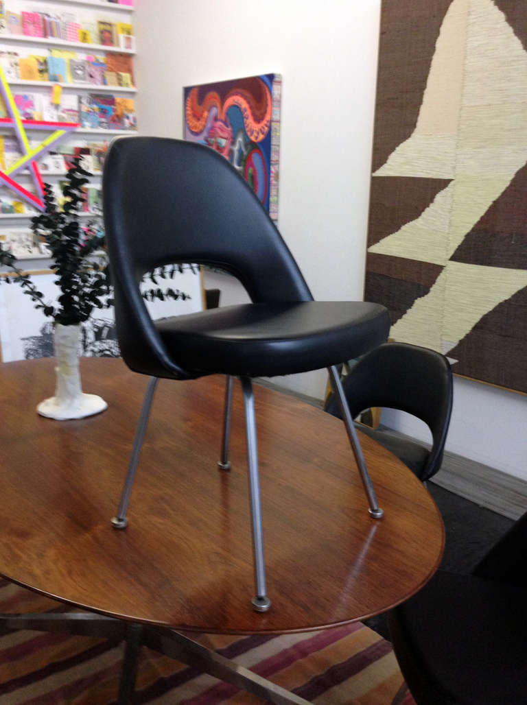 A set of 1960's Eero Saarinen Executive armless side chairs designed for Knoll International. Chairs are upholstered in black vinyl and have tubular steel legs. 10 chairs available for purchase together or separately.