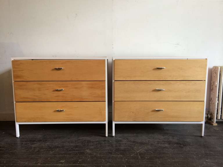 A pair of three drawer cabinets from the Steel Frame Group, designed by George Nelson for Herman Miller in 1952. White frame with white laminate top, drawers have been refinished to their natural wood. Label inside top drawer for each.