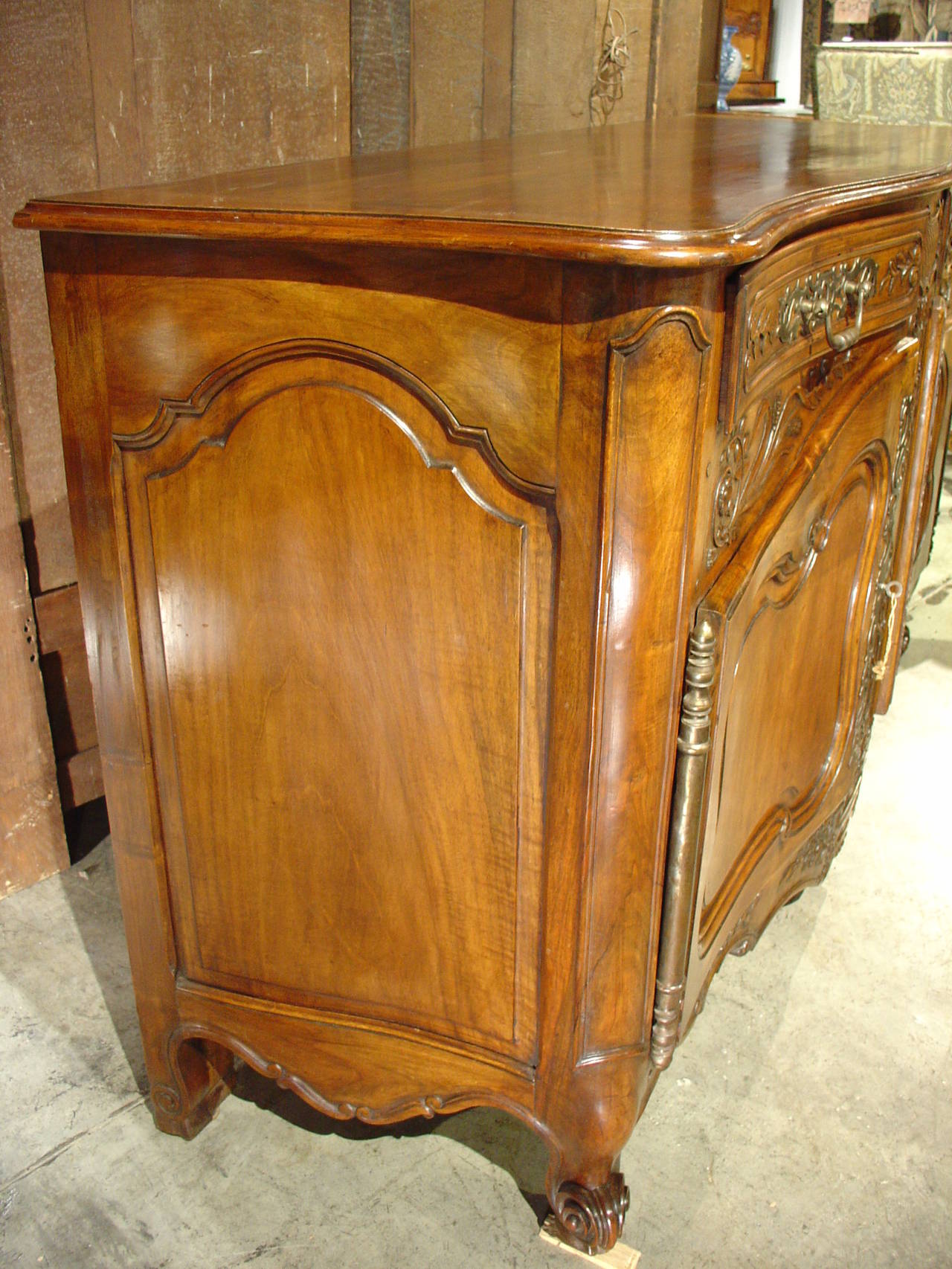 This exquisite large antique French buffet is typical of Provence.  Constructed from French walnut wood, it has two front doors and two drawers, with the left drawer having silverware separators.  The carving on this piece is magnificent and very