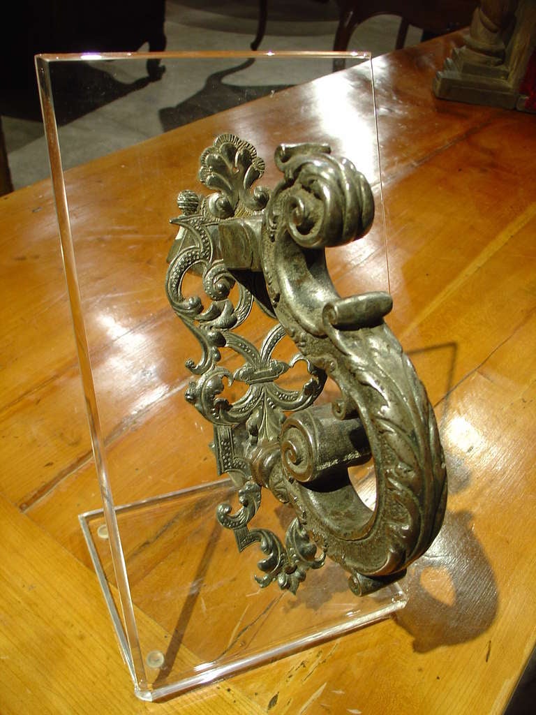 Northern Italy C.1650

This beautifully hand worked Northern Italian door knocker has been mounted upon a Plexiglas stand for viewing.  It has motifs of palmettes, banding, a cartouche, c scrolls, acanthus leaves, patterned grounds, hand punched