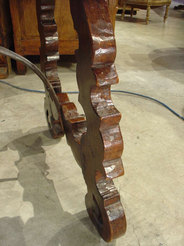 This antique Catalan table from Spain has a wonderful rustic top and lyre shaped legs. They are connected with hand forged antique iron stretchers.  Catalan style tables were originally made to be disassembled easily due to the war in the Middle