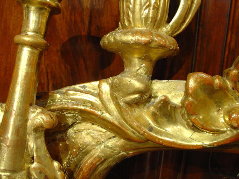 This magnificent Italian, giltwood eight arm candelabra is from the 1700’s and has been hand carved.  The motifs are floral and foliate in nature with punched decoration of circles and stars at the base. Traces of red bole show through the gilding