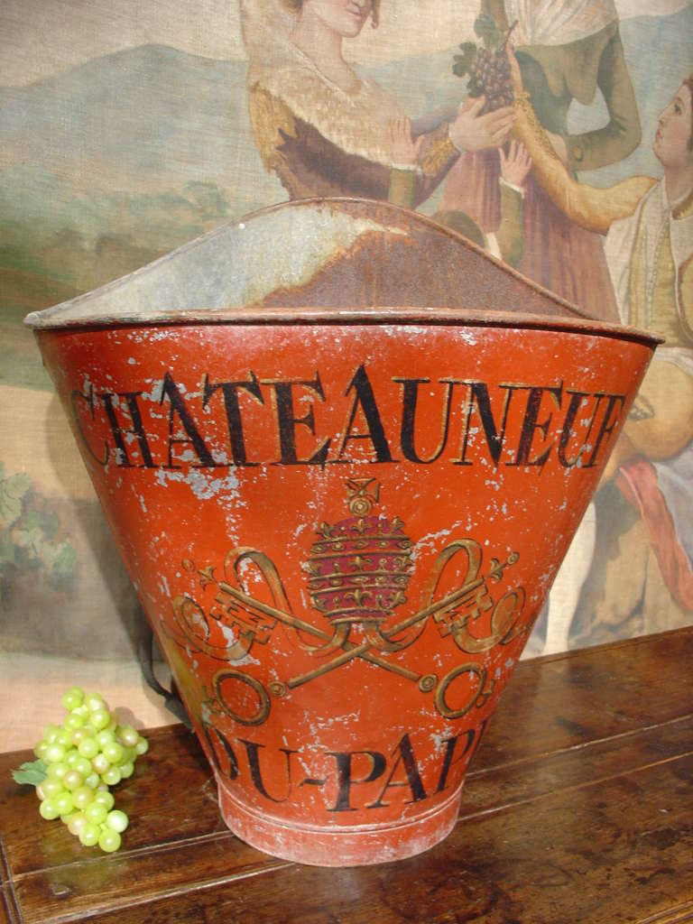 This red painted metal wine grape carrier features the famous Chateauneuf vineyard crest and would have been used for transporting grapes around 1920. It can now be used as the perfect decorative accessory in a wine room, or to store firewood, etc.