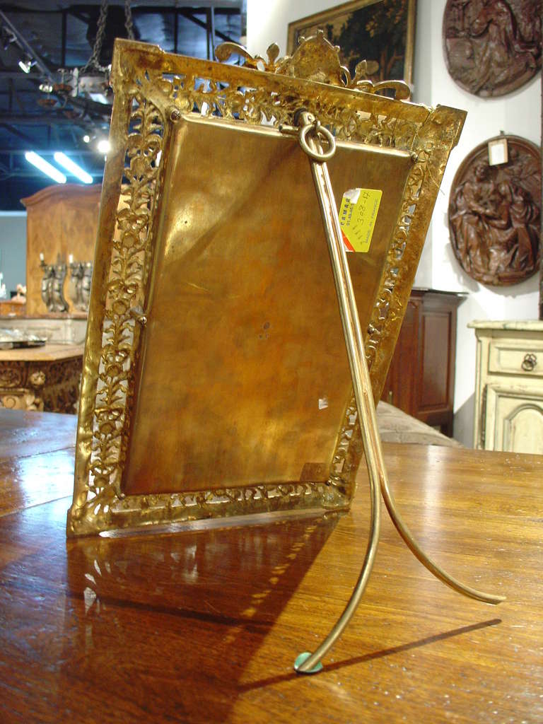 A beautiful Antique French Table or Wall Beveled Mirror ( Gold Electroplating (over Bronze) with Decoration in the Regence Style- Several Marks to back, including a company trademark.   It has a stand to the back as well as a loop for wall hanging. 